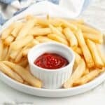 Plate of french fries with a bowl of ketchup.