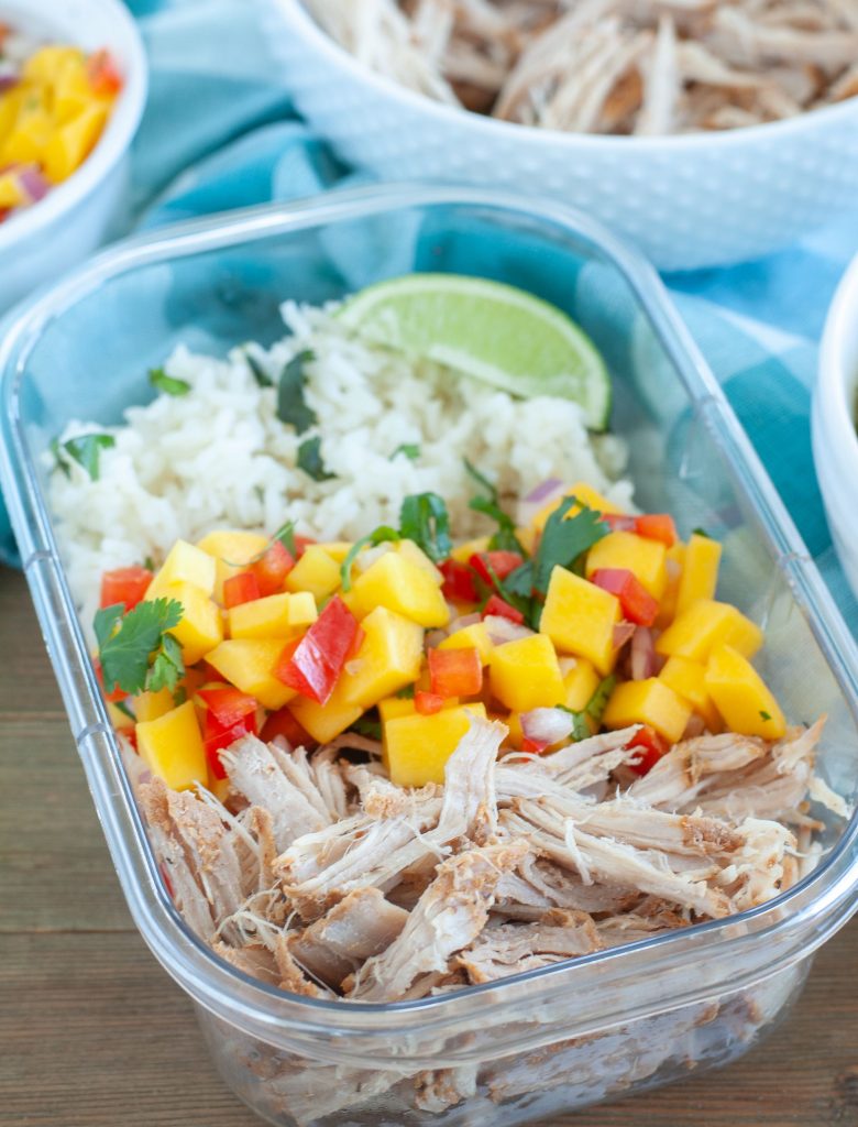 Shredded carnitas, mango salsa and rice in a plastic container