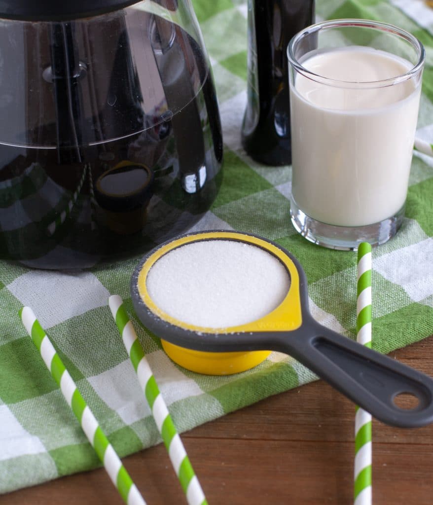 Coffee, sugar, cream and green straws