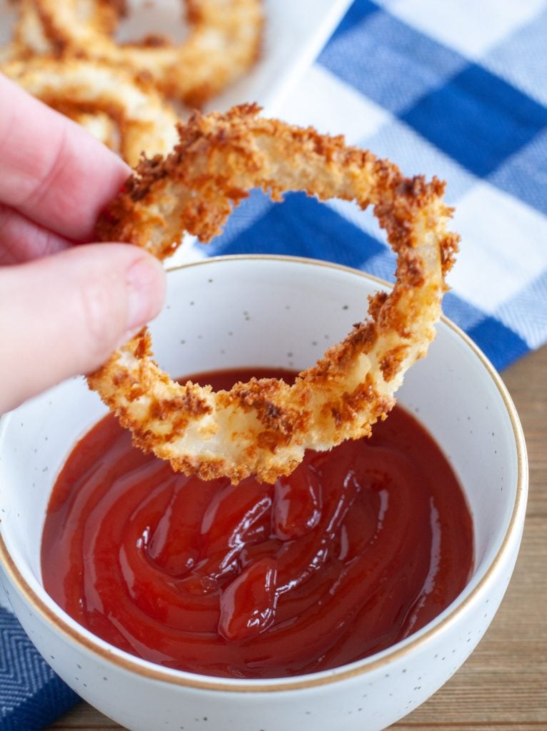 Onion ring being dipped in ketchup