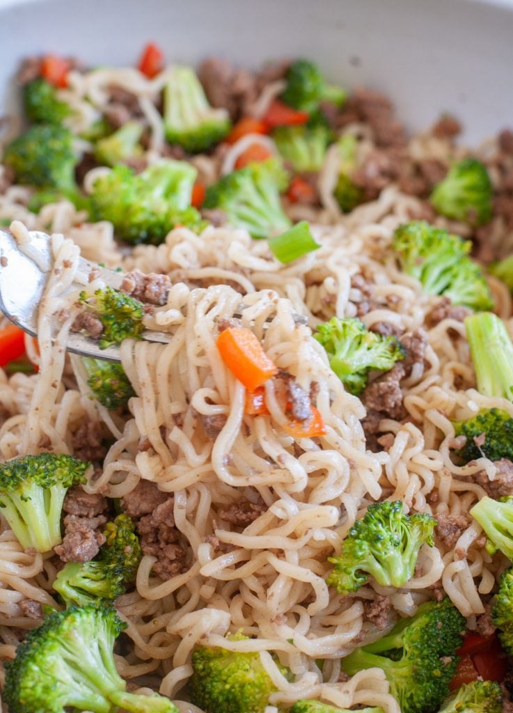 Noodles on a fork with peppers and broccoli