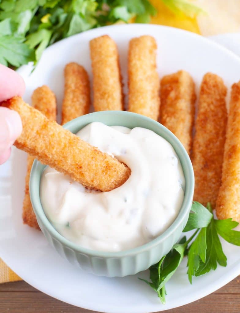 Bowl of tartar sauce with fish sticks