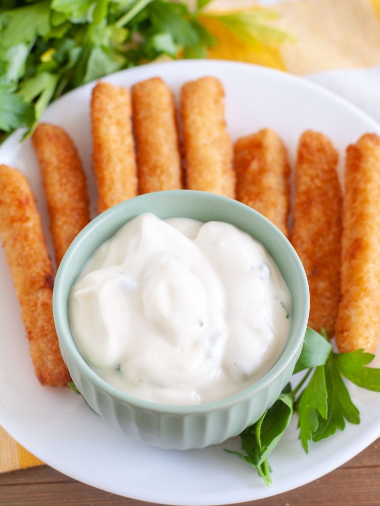 Tartar sauce in a bowl with fish sticks