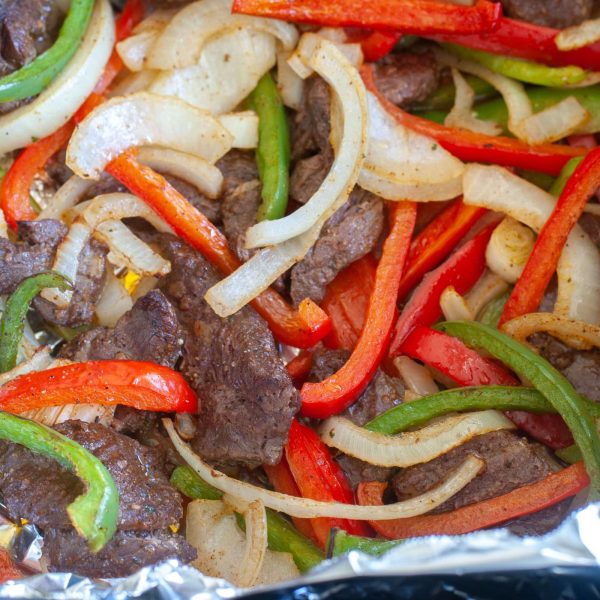 Steak, peppers and onions in foil.
