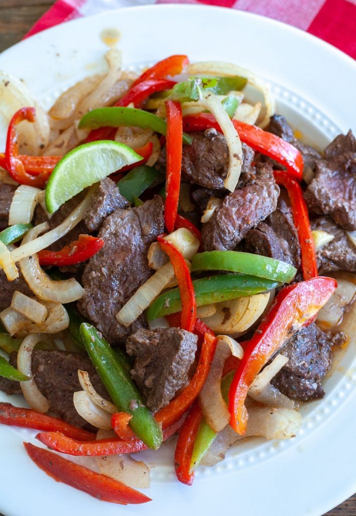 steak peppers and onions on a white plate