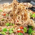 Ramen noodles with vegetables in a skillet.