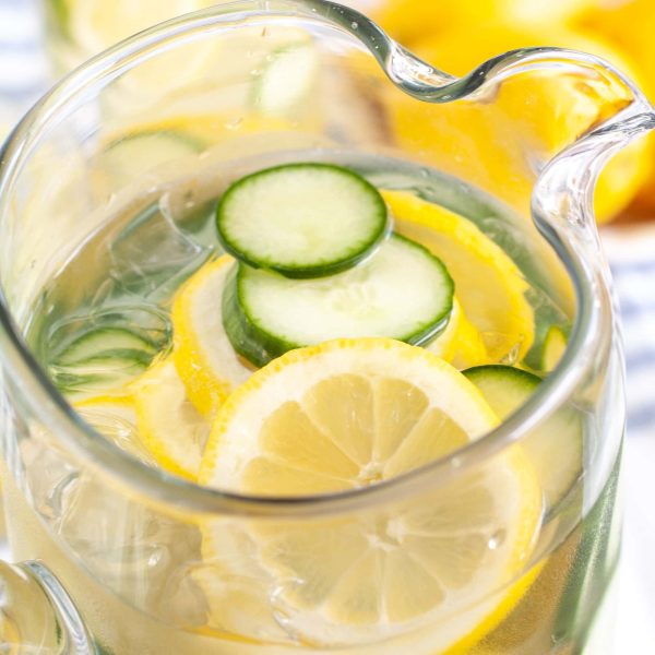 Pitcher with water, lemon and cucumbers.