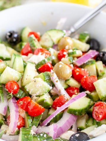 Cucumber tomato salad in a bowl with a fork