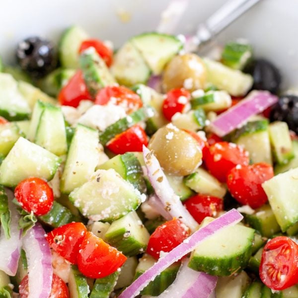 Cucumber tomato salad in a bowl with a fork