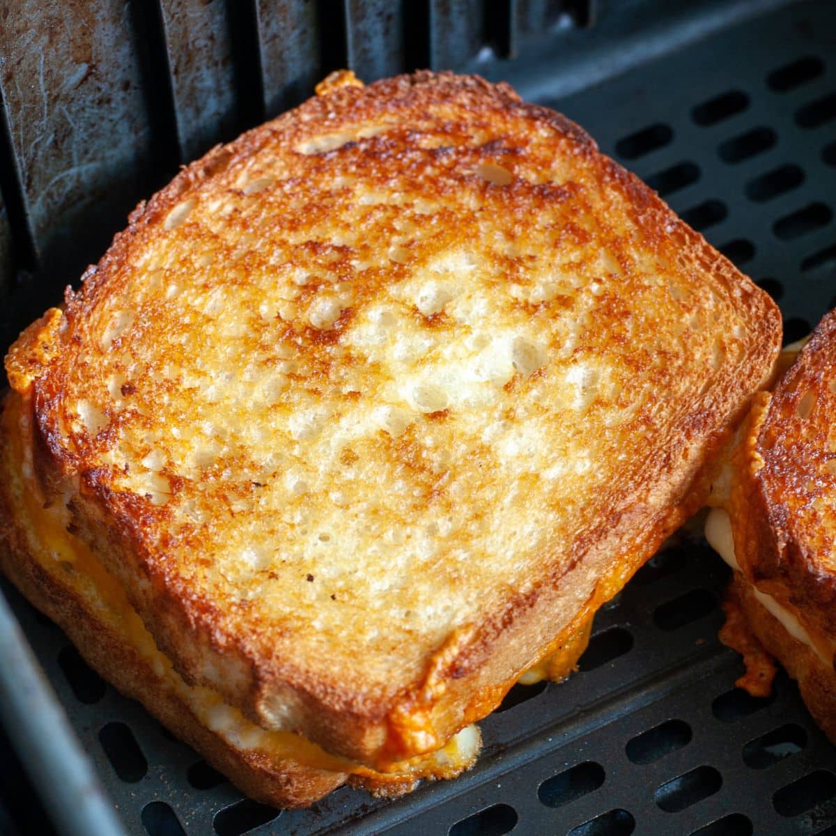 Grilled cheese sandwich in an air fryer basket.