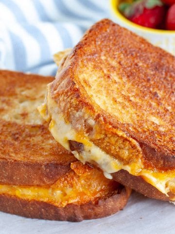 Two grilled cheese sandwiches on a plate.