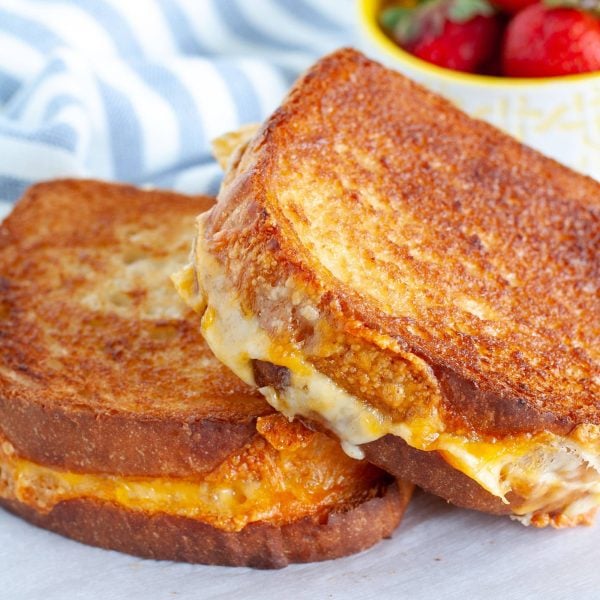 Two grilled cheese sandwiches on a plate.