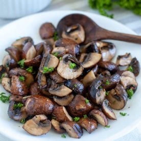 Cooked mushrooms on plate with spoon.