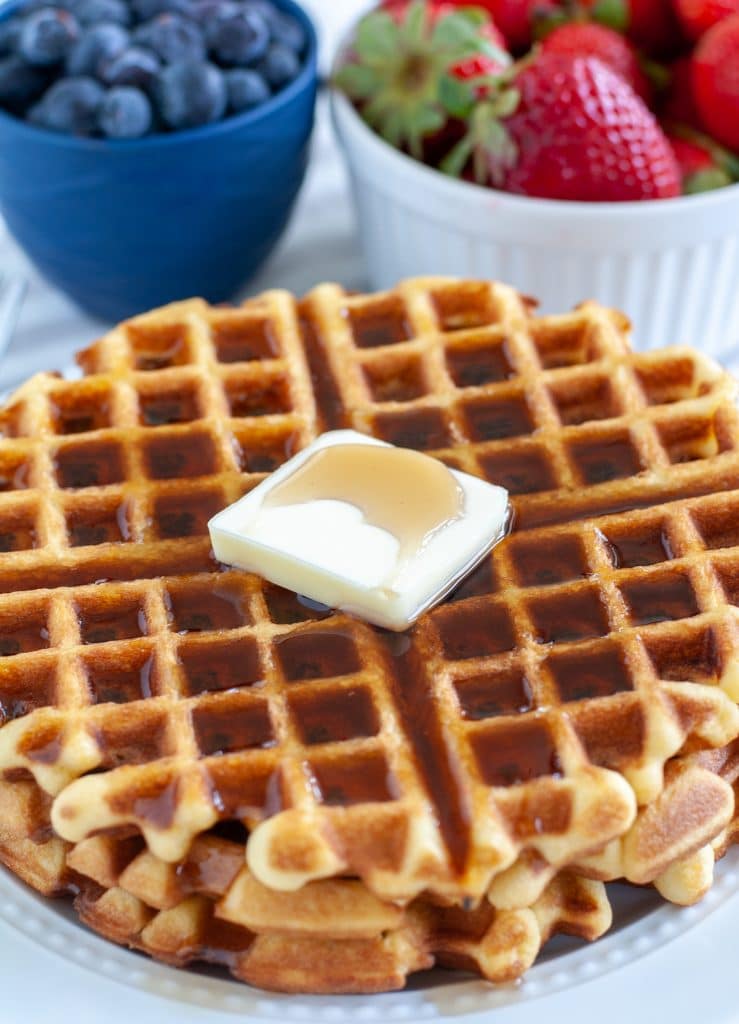 Waffles on a plate with butter and syrup