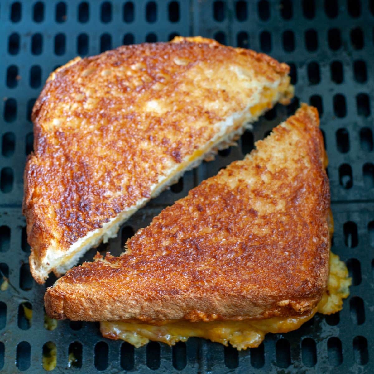 Grilled cheese sandwich in an air fryer basket.