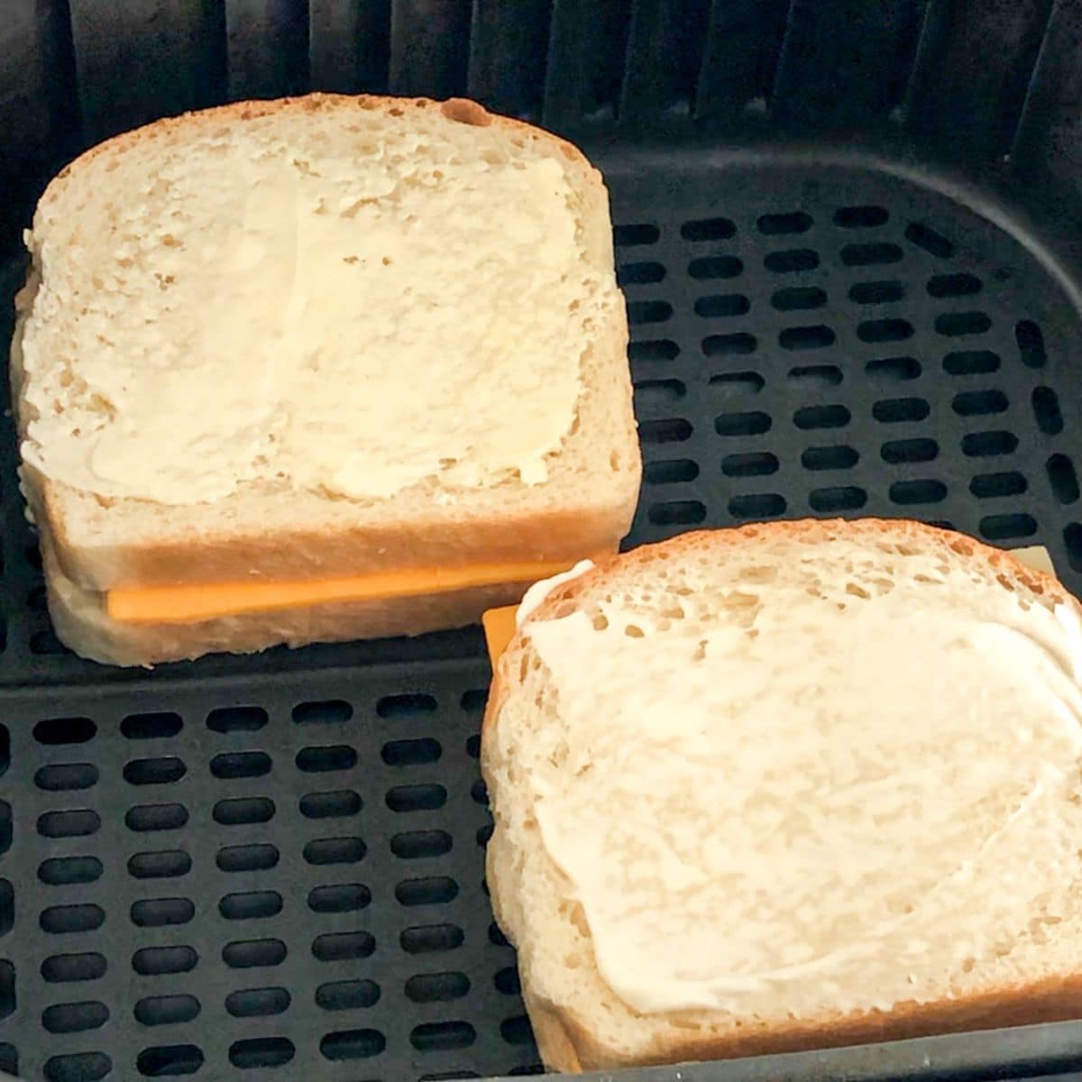Uncooked grilled cheese sandwiches in the air fryer.