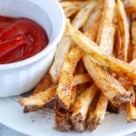 French fries on plate with ketchup.