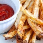 Plate of french fries with bowl of ketchup