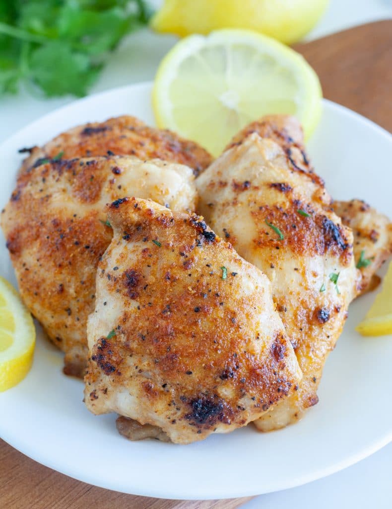 chicken thighs on a plate with lemons