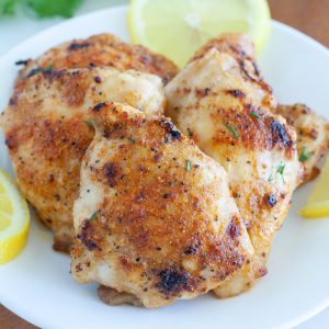 chicken thighs on a plate with lemons