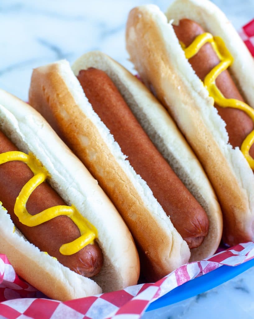 three hot dogs in blue basket