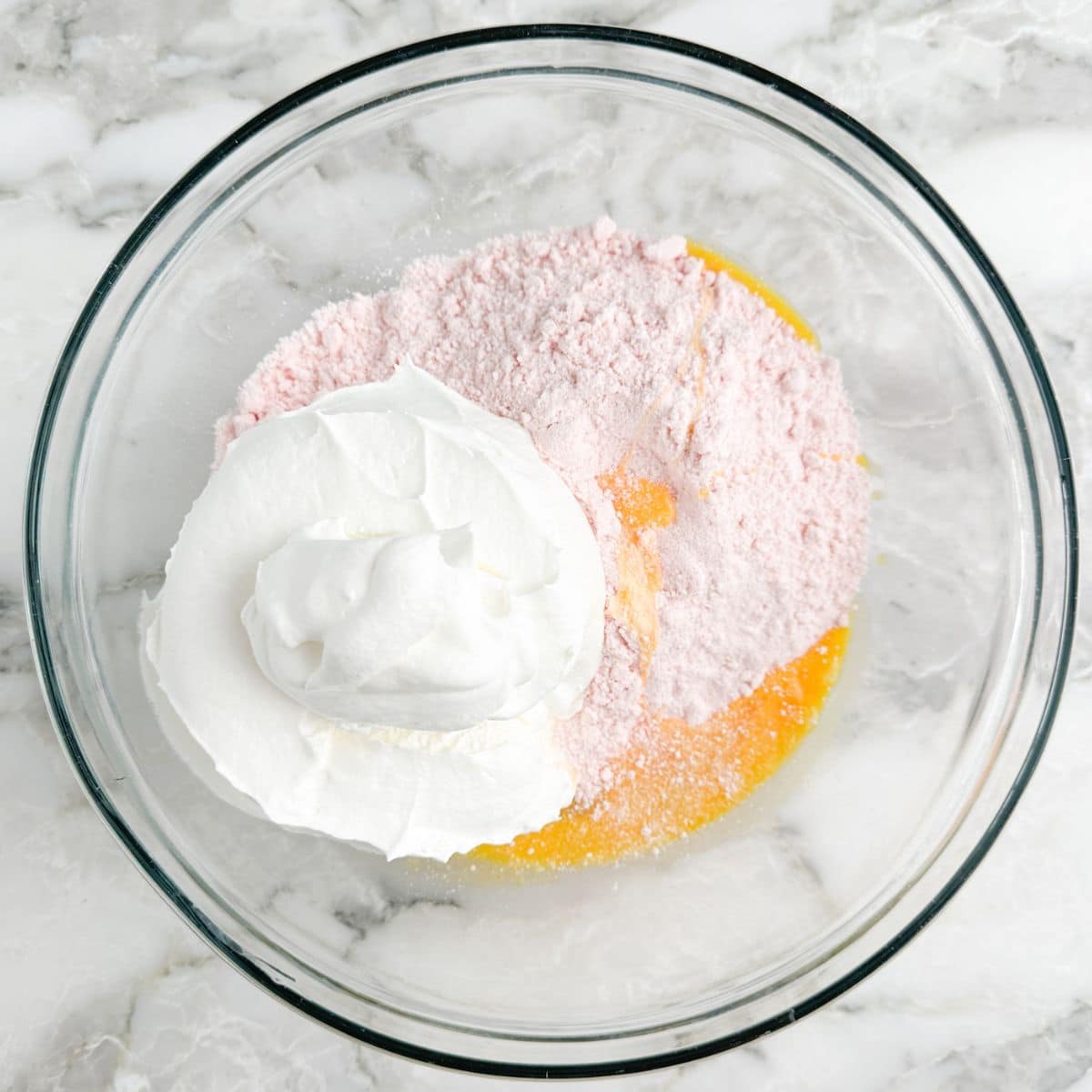 Bowl with cake mix, whipped topping, and egg.
