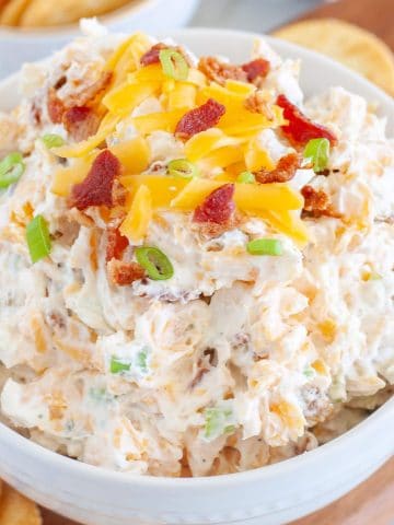 Crack dip in bowl topped with bacon and cheese