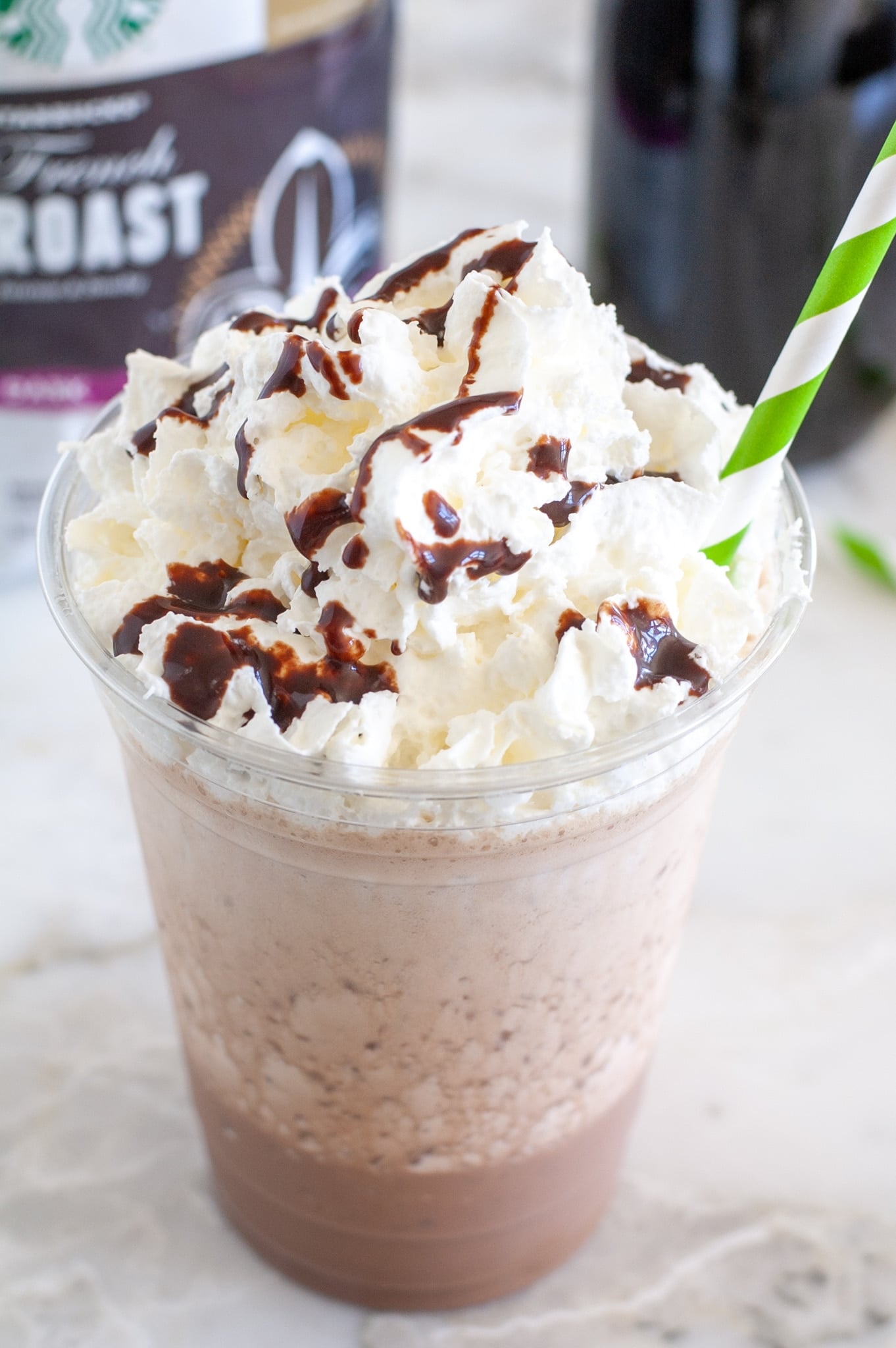 Creamy Mocha Freeze 2 Homemade Mocha Frappuccino in a glass, topped with whipped cream and chocolate drizzle.
