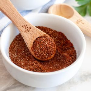 Chili spices in a bowl with wooden spoon