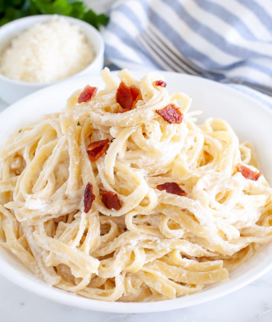 Pasta on plate with cream cheese sauce and bacon bits