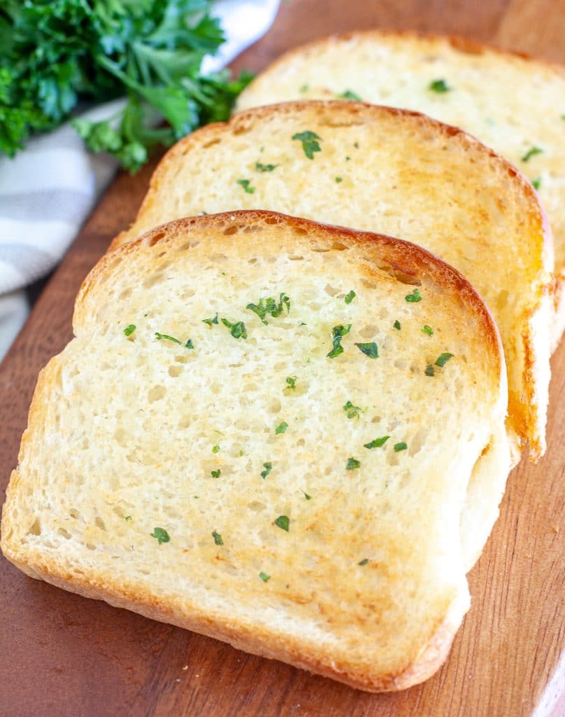 Three pieces of toast on a board. 