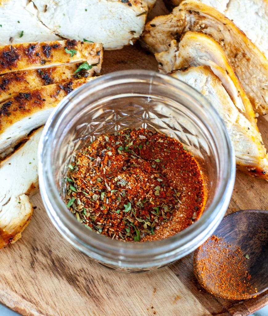 seasonings in a jar with sliced chicken