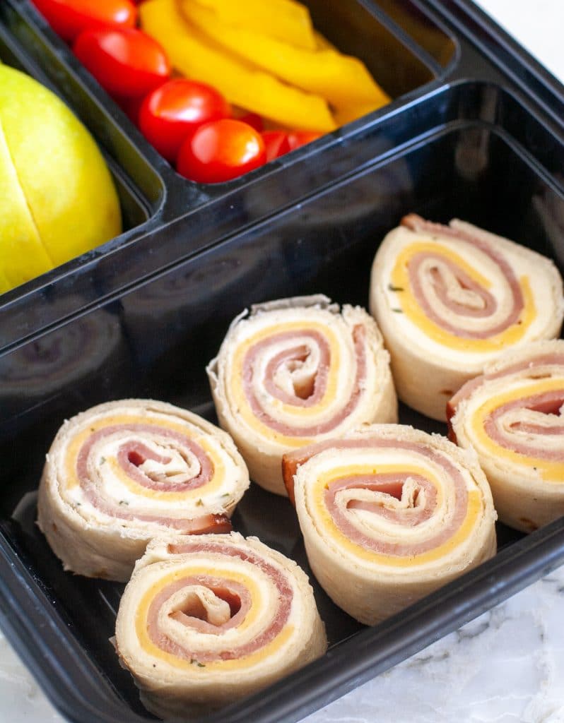 roll ups in box with apple, tomato and peppers