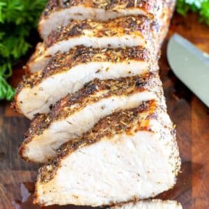 Juicy sliced air fryer pork loin roast on a cutting board.