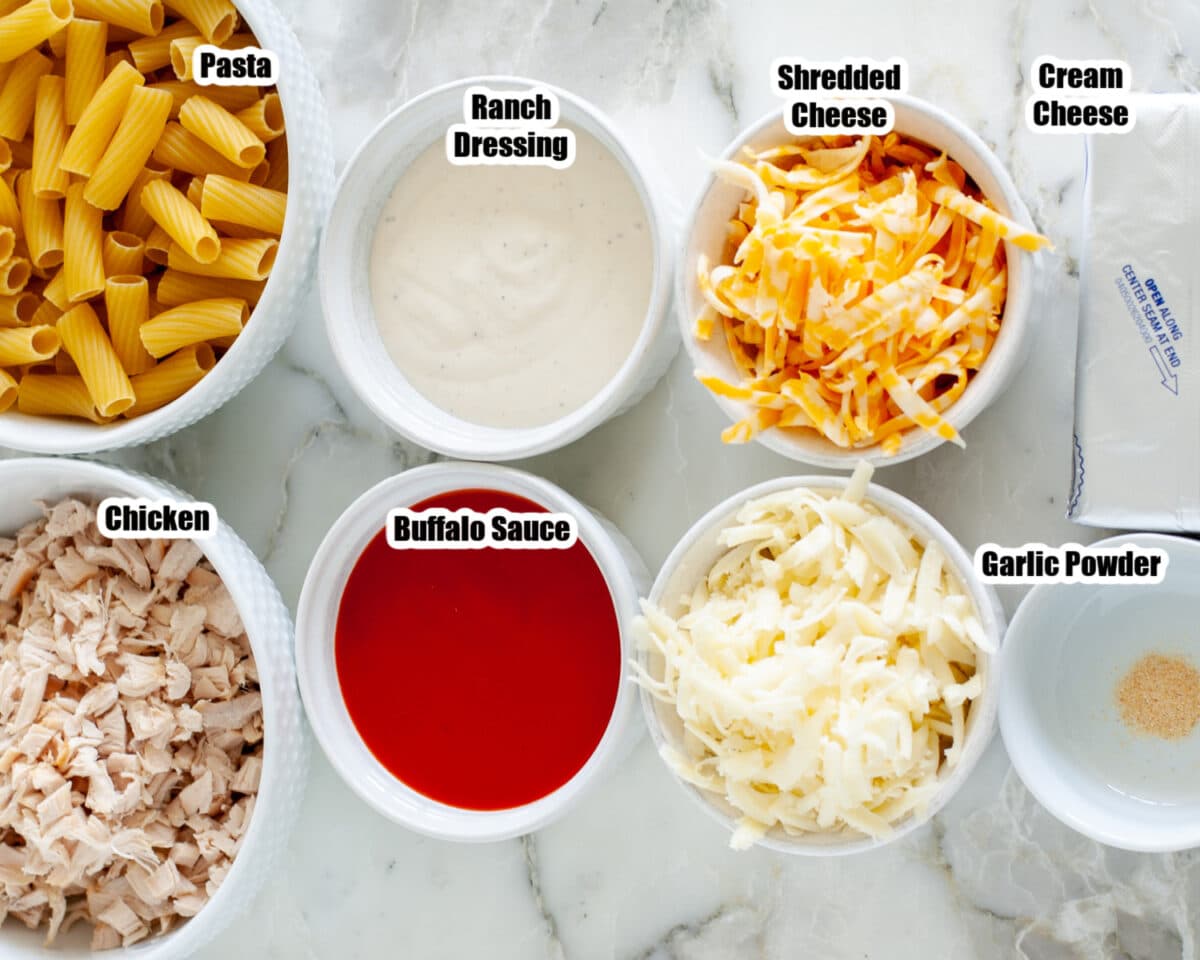 Bowl of chicken, pasta, shredded cheese, ranch, buffalo sauce, and cream cheese.