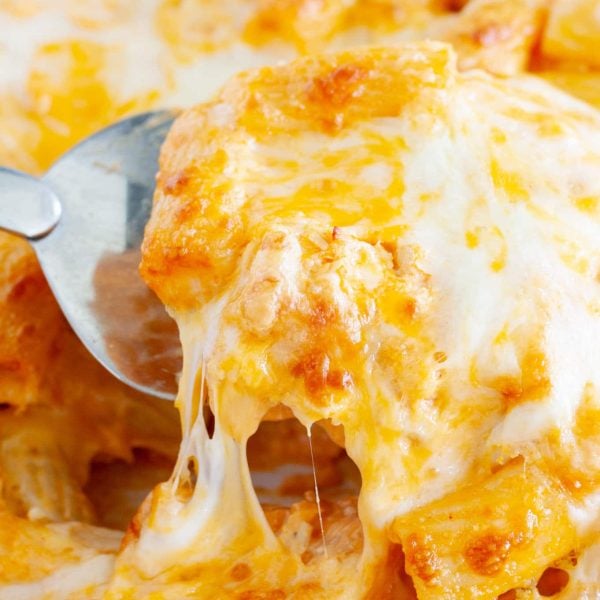 Spatula holding cheesy pasta casserole.