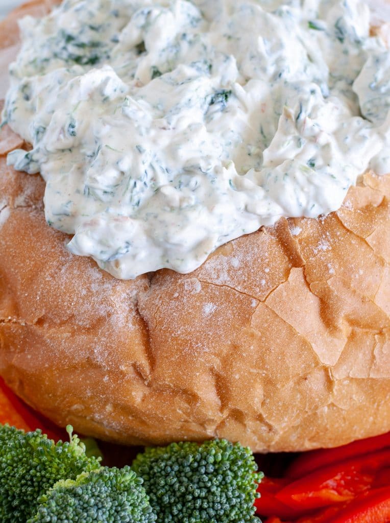 Spinach dip in bread bowl with vegetables