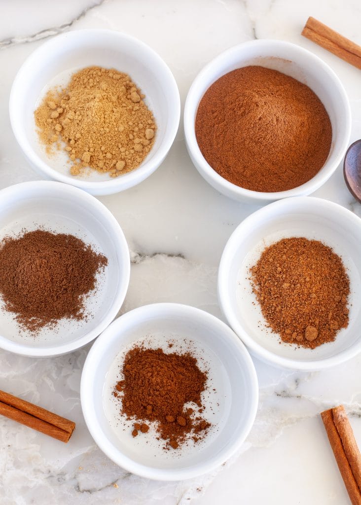 spices in bowls with cinnamon sticks