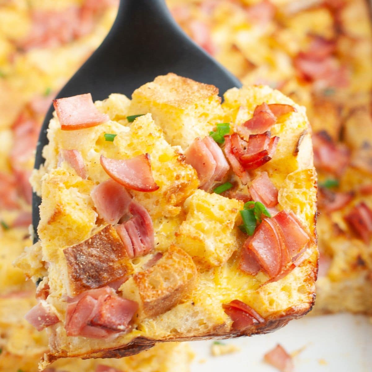 Spatula with a piece of eggs Benedict casserole.