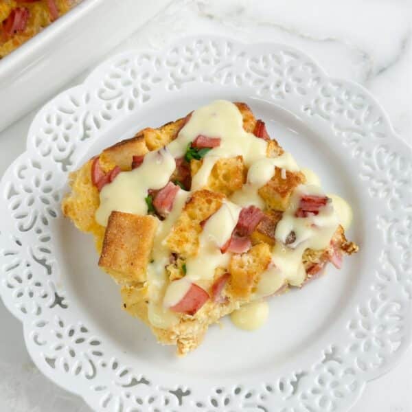 Plate with a piece of eggs Benedict casserole topped with Hollandaise sauce.