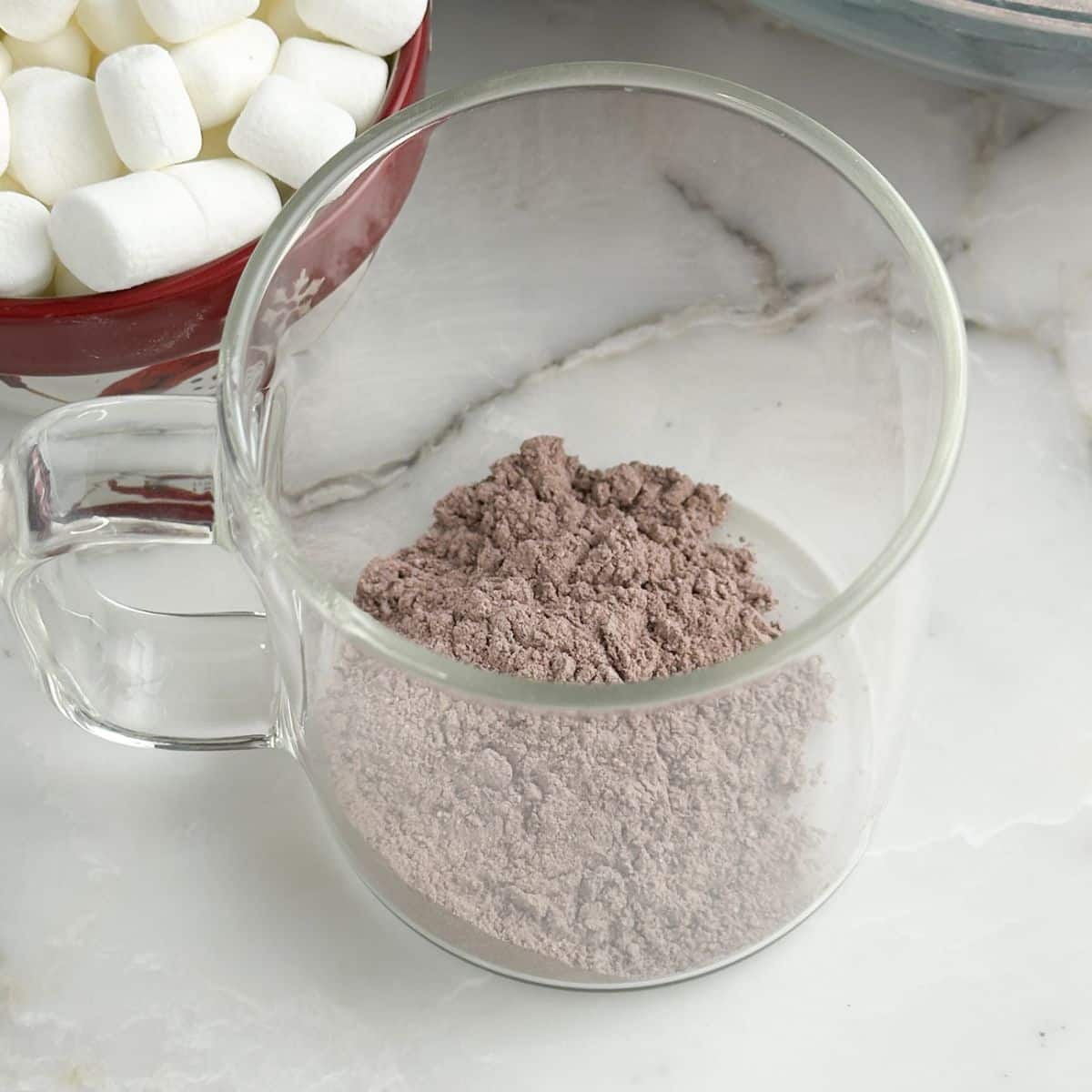 Clear mug with hot chocolate mixture in the mug.