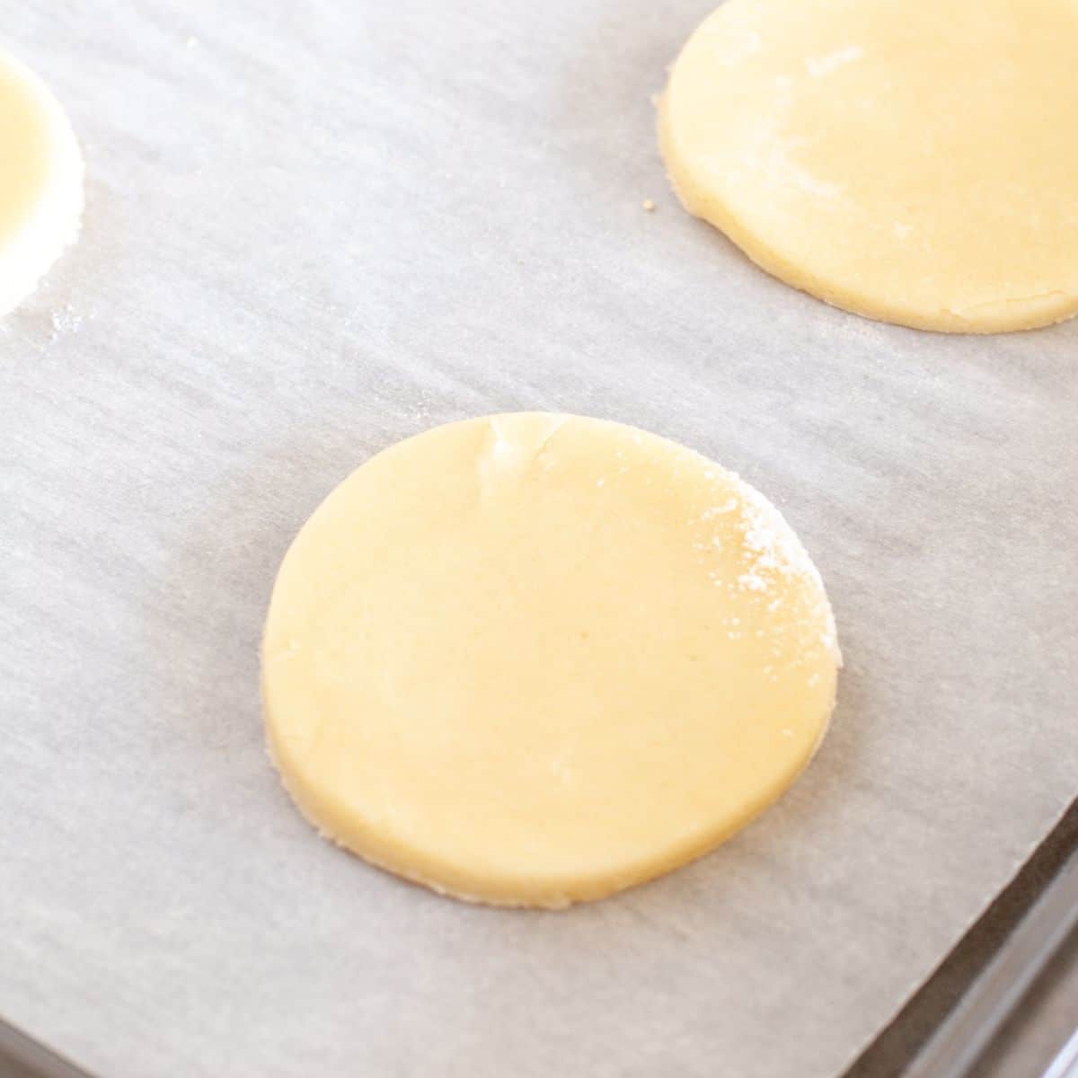Unbaked sour cream cookies on a baking sheet.