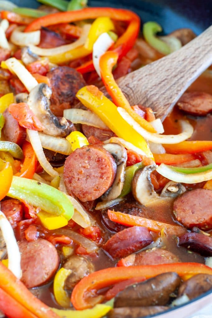 Wooden spoon with sausage and peppers. 