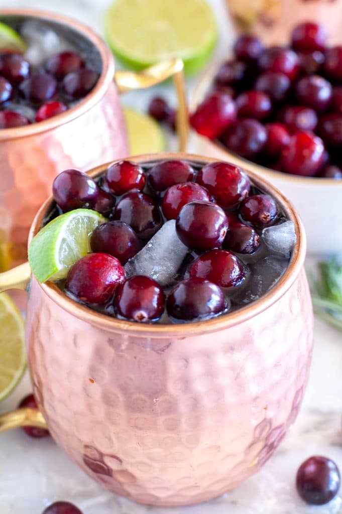 Copper cup with ginger beer, cranberry juice and lime wedge.