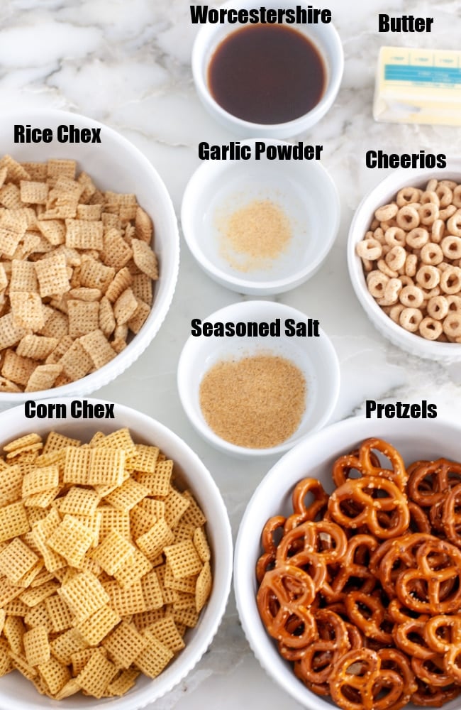 Chex cereal in a bowl, butter, pretzels in a bowl, Cheerios in a bowl.