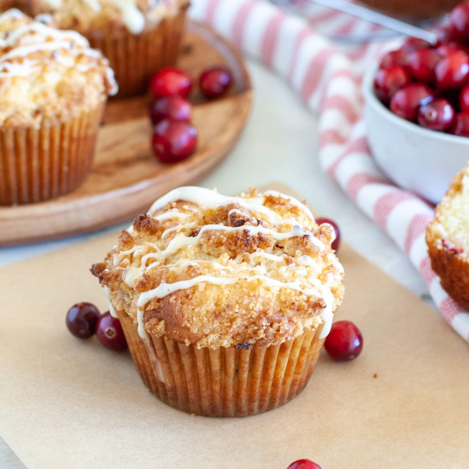 Muffins on a plate and on paper with cranberries.