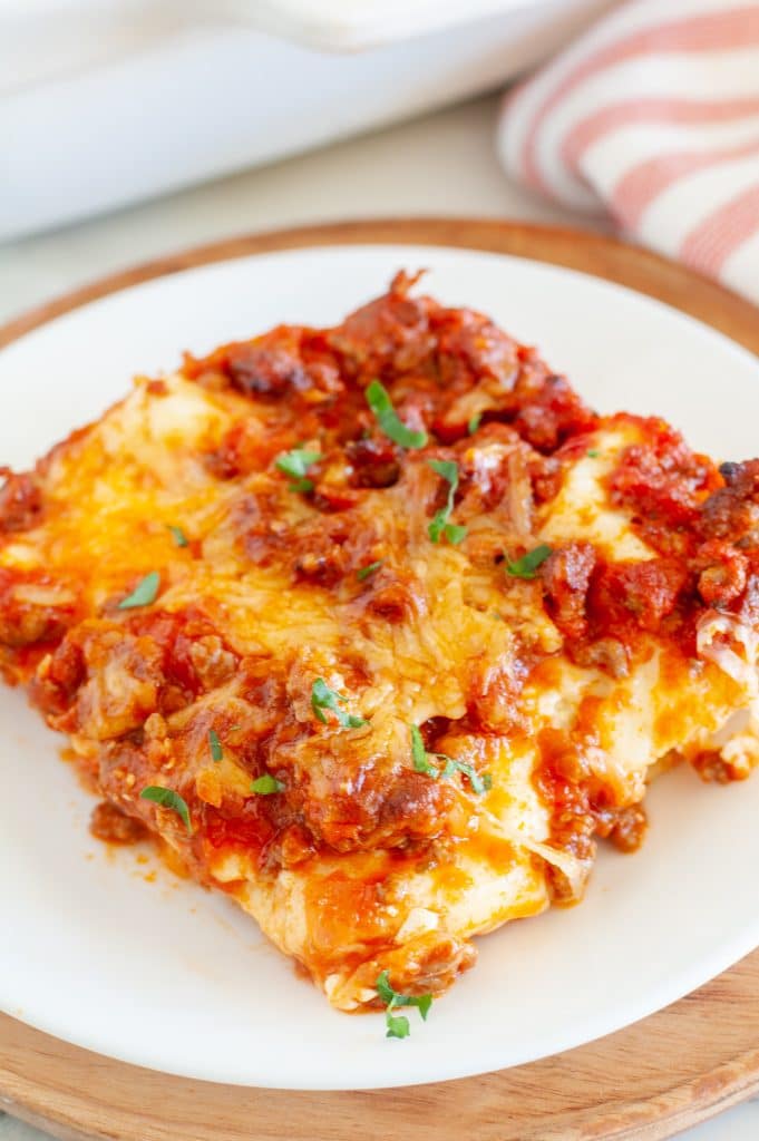 Piece of lasagna on a white plate. 