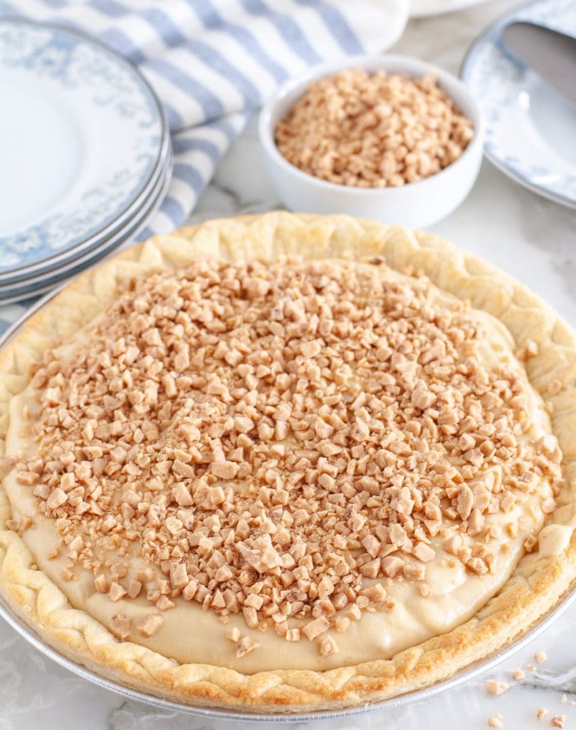 A whole pie topped with toffee bits. 