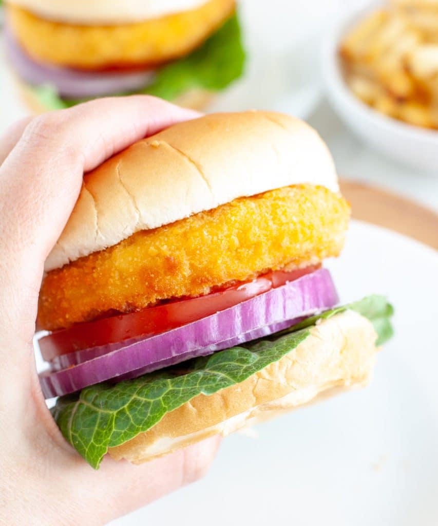 Hand holding chicken sandwich. 