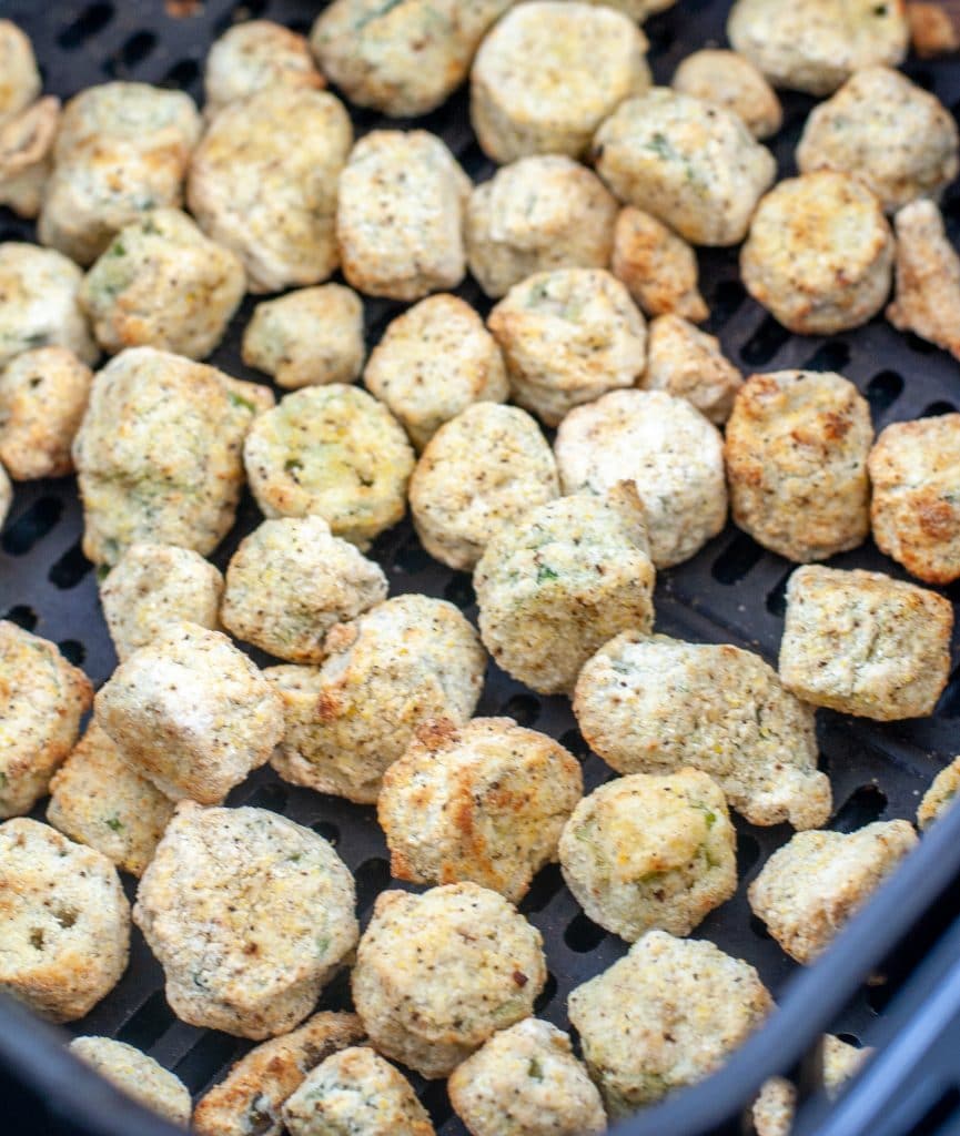 Cooked breaded okra in air fryer basket. 